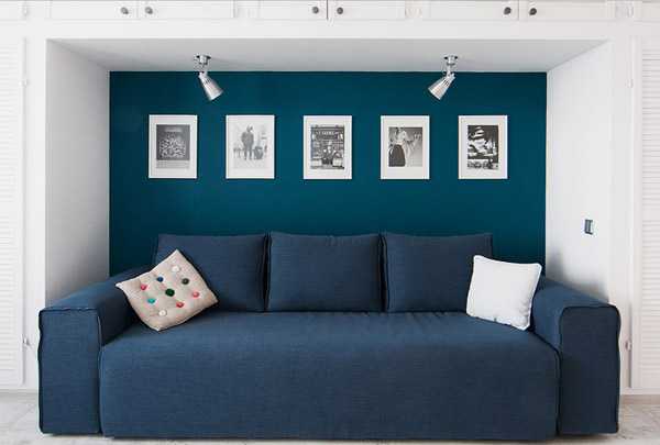 синий диван, фоторамки на синей стене