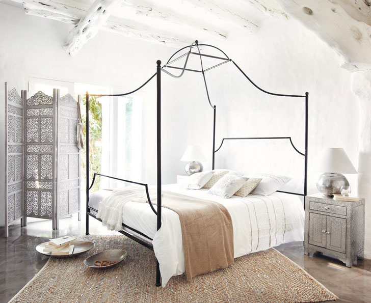 Спальня с большой кроватью с белоснежными оштукатуренными стенами