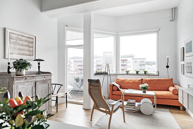 Маленькая белая квартира с оранжевым диваном и антресолью (49 кв. м)