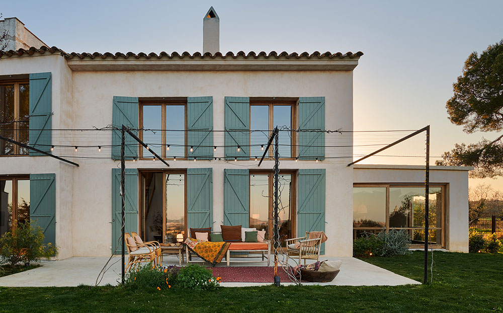 Окна с бирюзовыми ставнями и тёплые тона: уютный современный дом в Испании