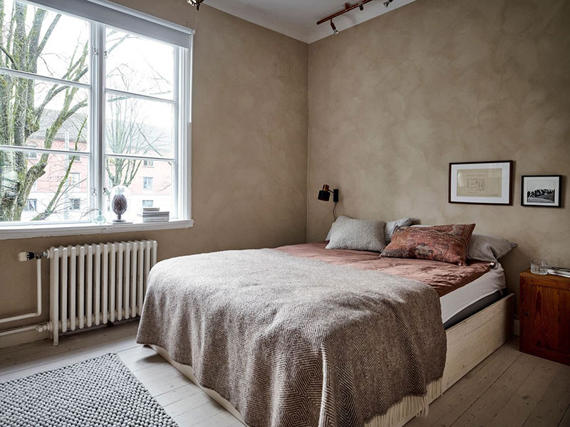 Кирпичная стена, винтажные нотки и белая лестница: необычная квартира в Швеции