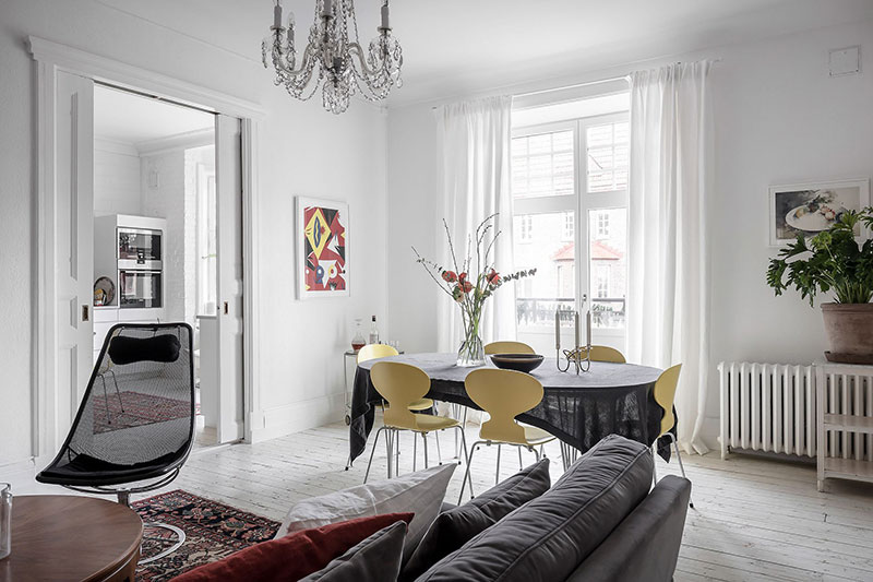 Белоснежная квартира в Швеции с жёлтыми стульями и пёстрыми коврами