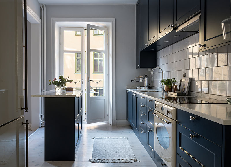 Синяя кухня, картины и спальня в тёмных тонах: изысканная небольшая квартира в Стокгольме (61 кв. м)