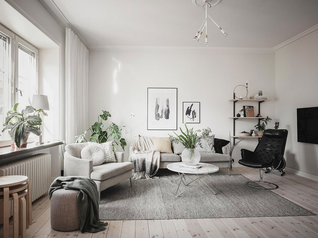 Просторная шведская квартира с тёмно-серой кухне и рабочей зоной в спальне