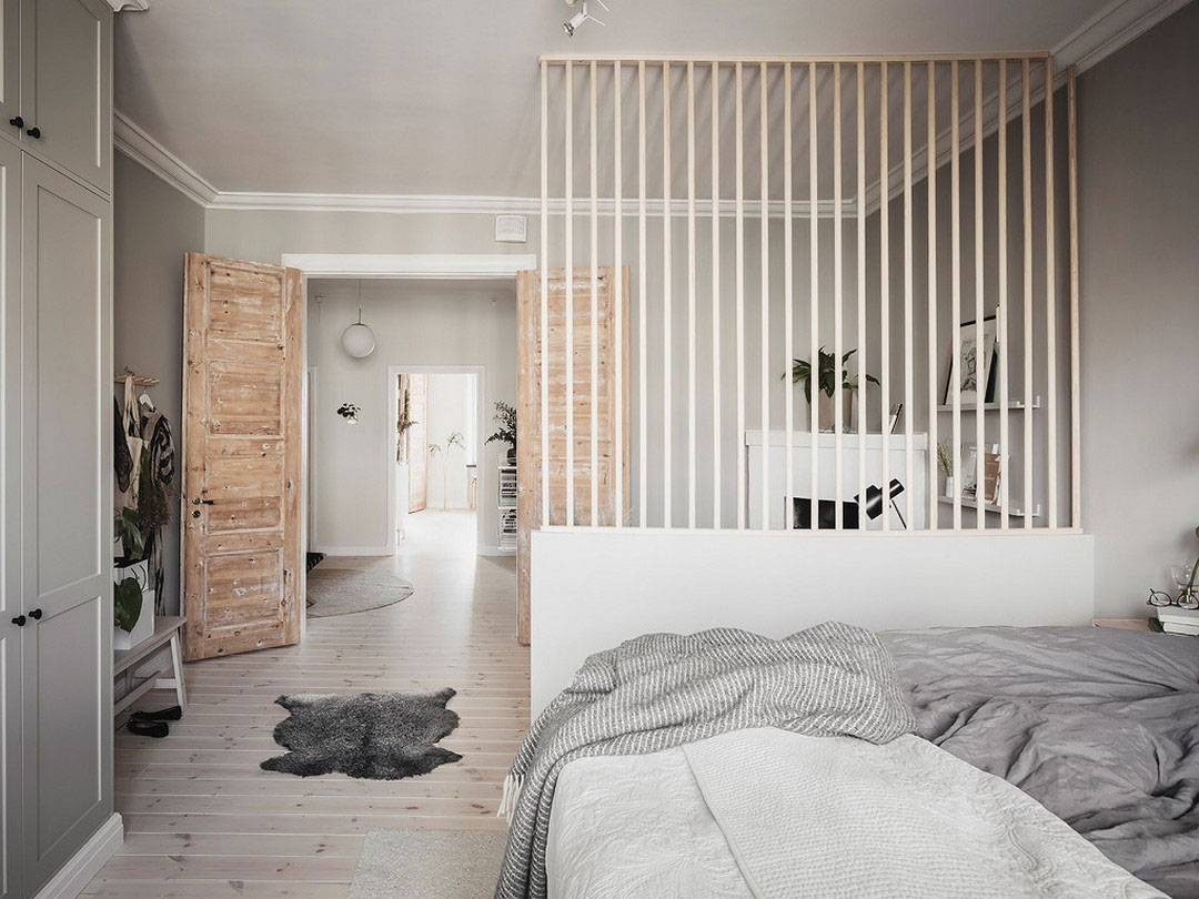 Просторная шведская квартира с тёмно-серой кухне и рабочей зоной в спальне