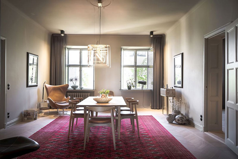 Красный ковёр, жёлтый шкаф и необычные люстры: броский интерьер квартиры в Швеции