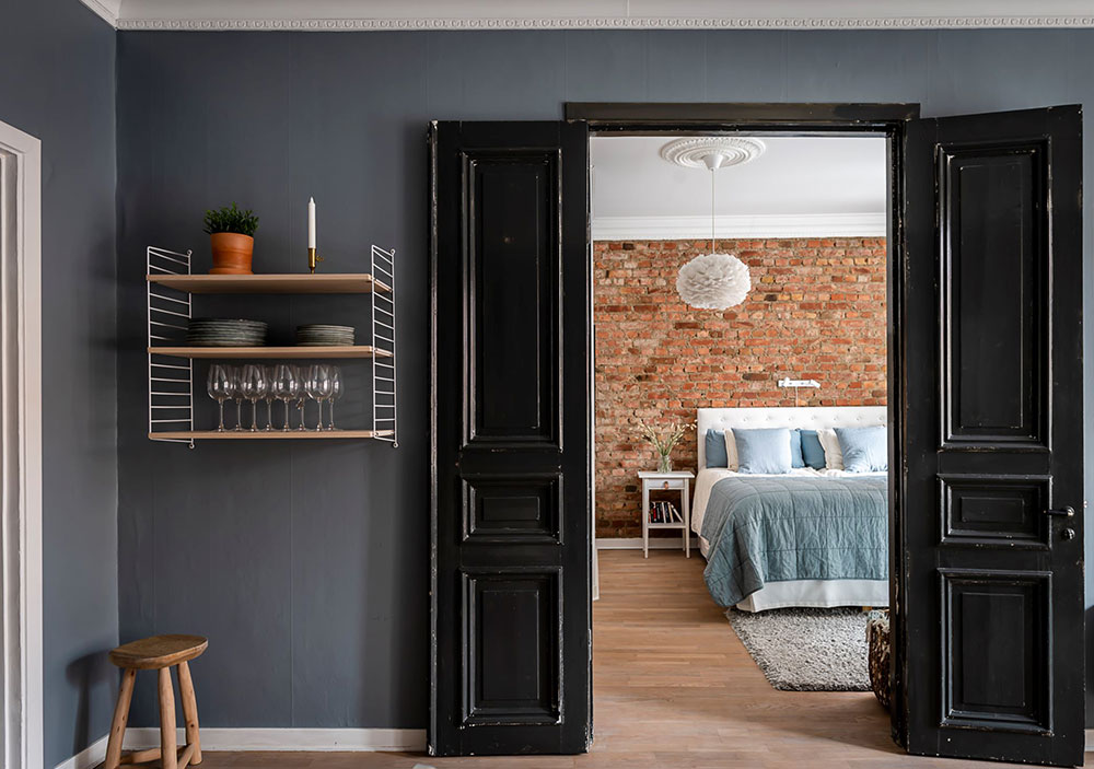 Кирпич, синие стены и чёрные двери: смелый интерьер квартиры в Гётеборге