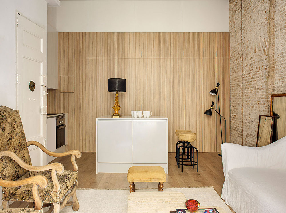 Белая квартира-студия с кирпичной стеной и антикварными креслами в Барселоне (60 кв. м)