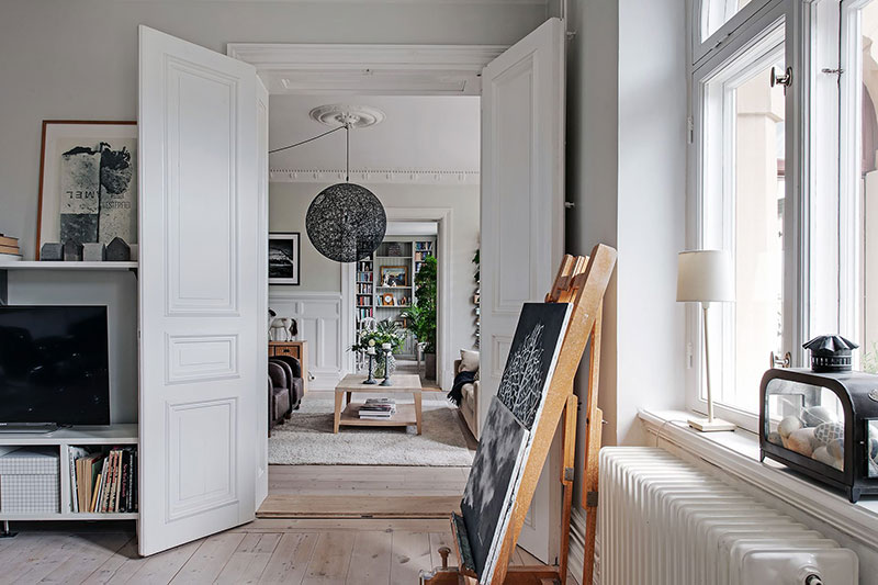 Просторная кухня с островом и библиотека в столовой: большая квартира в Швеции