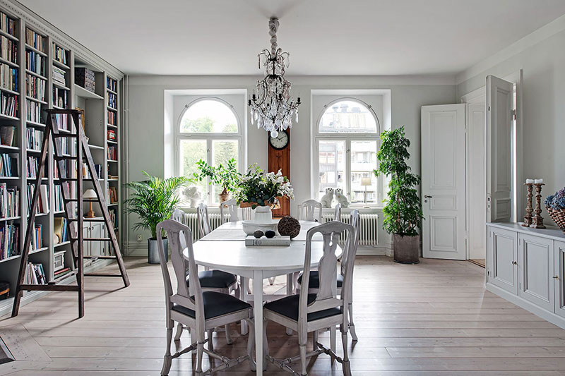 Просторная кухня с островом и библиотека в столовой: большая квартира в Швеции