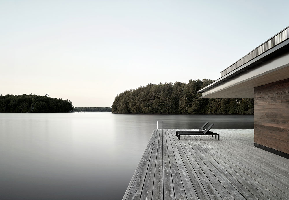 Современный деревянный коттедж с эллингом на берегу озера в Канаде
