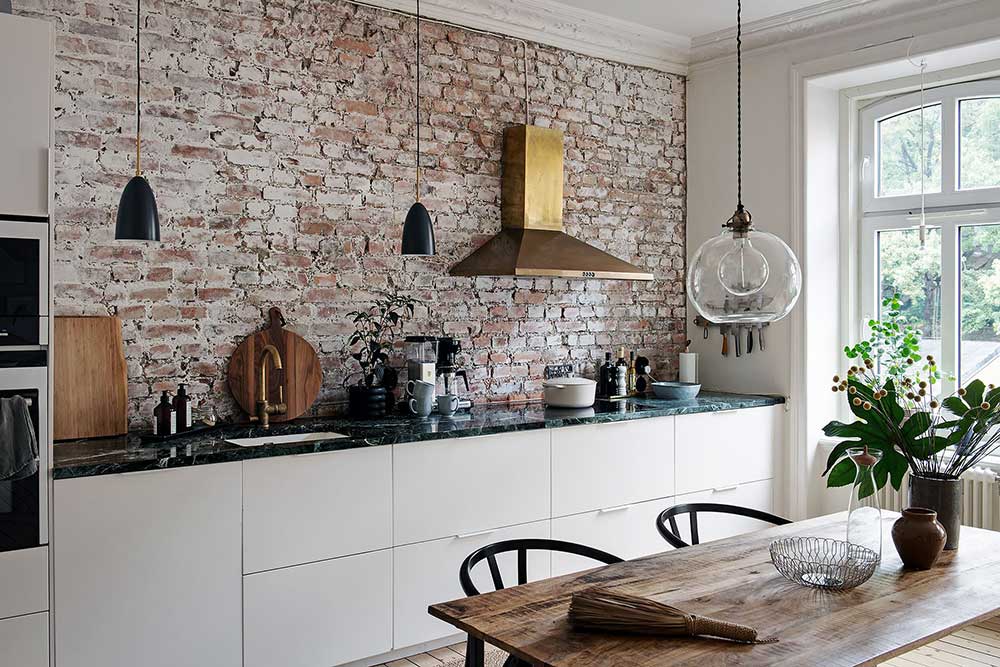 Кирпичная стена на кухне и золотая вытяжка: интересный интерьер в Гётеборге (87 кв.м)