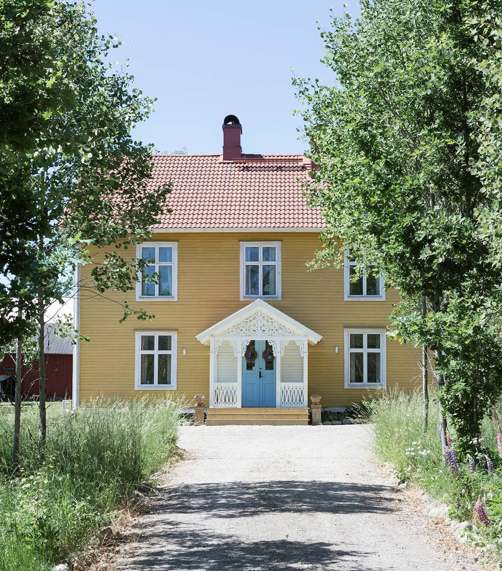 Красивый жёлтый коттедж 19-века с голубой дверью в Швеции