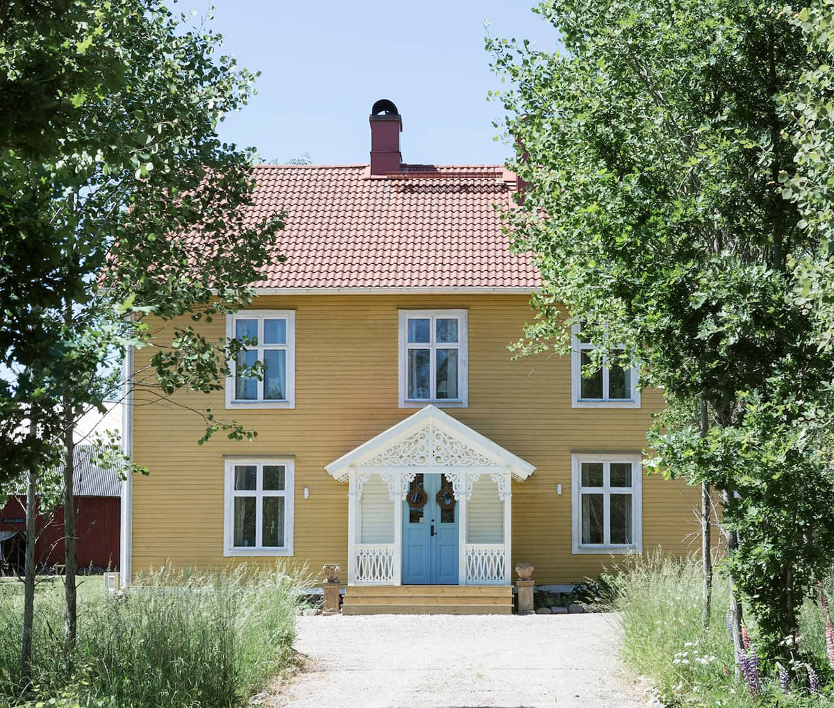 Красивый жёлтый коттедж 19-века с голубой дверью в Швеции